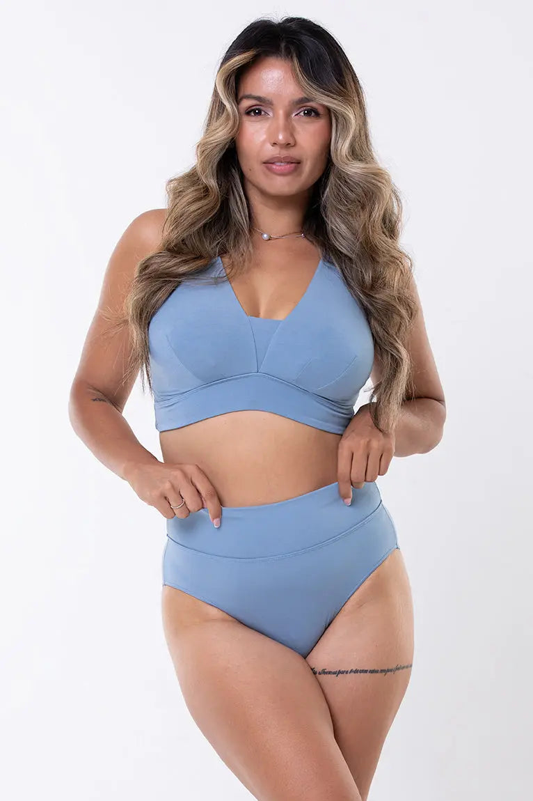 A female model wearing a Australian made blue Adele Bralette, which is a wire-free bra designed to offer mid-level lift and support, suitable for larger cup sizes.